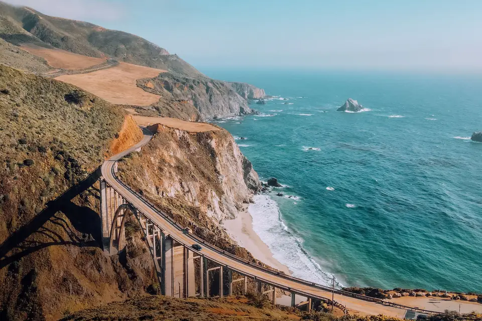 Bixby Creek Bridge on Highway 1, curving along cliffs above a sandy cove and the turquoise Pacific on the Big Sur coast south of Carmel